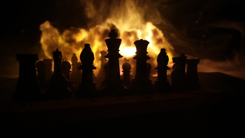 Chess board game concept of business ideas and competition or war theme. Chess figures on a dark background of explosion and fire clouds. Selective focus | Shutterstock HD Video #1089894915