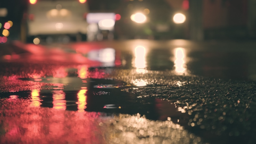 A pond and running cars at night on a rainy day, driving background, Nobody