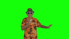Happy old man dancing while wearing summer clothes in the studio. Shot in 4k resolution with green screen background