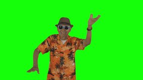 Happy old man dancing while wearing summer clothes in the studio. Shot in 4k resolution with green screen background