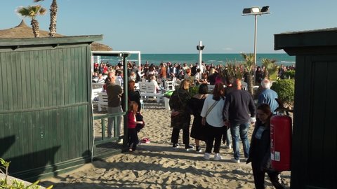 Ostia, Rome, Italy - April 25, 2022, a party with a singing ensemble, entertaining and dancing the crowd on the beach, in a bathhouse.