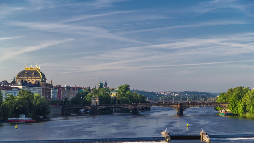 Vltava river timelapse in district Strelecky ostrov with the bridge of the Legions (Most legii) and National Theater building early morning, Prague, Czech Republic