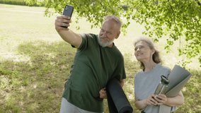 Happy senior couple taking a selfie in park. Close up footage of senior couple taking a selfie in park. Beautiful footage of senior couple smiling and taking selfie in park. Healthy lifestyle concept. - Powered by Shutterstock - Get 15% off with code: PIKWIZARD15