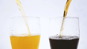 Two glasses are filled with pop soda close-up on a white background. Soda is poured into two glasses. 4k raw video 60 fps.