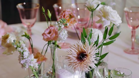 There are fresh flowers on the table and cutlery and glasses are visible behind them. Beautiful festive table
