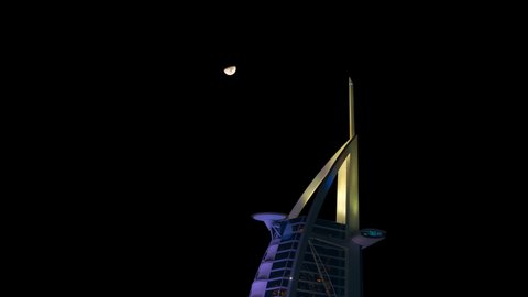 Dubai, United Arab Emirates - October 14 2021: Half moon passing Burj Al Arab Hotel in Dubai