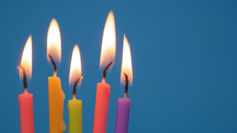 Lighted candles in a birthday cake on a blue background.Close up colorful flame candles in a homemade cake. birthday candles for home party