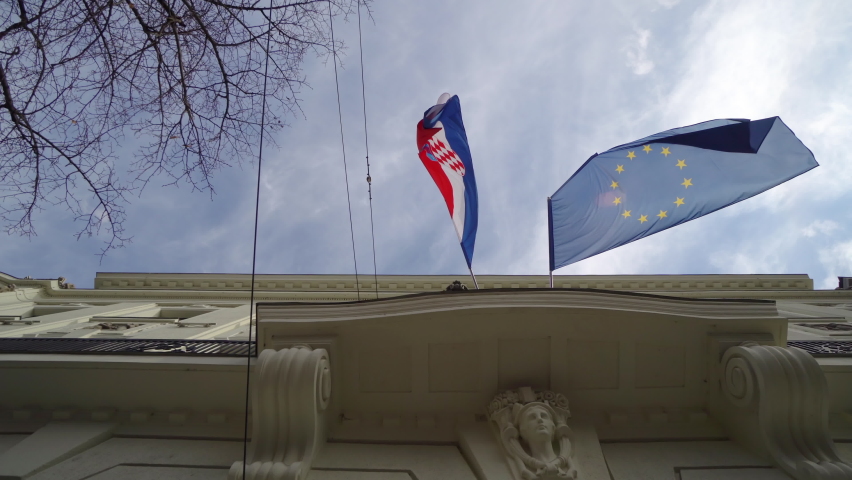 Croation flag and the flag of Europian Union against blue sky in Zagreb, Croatia