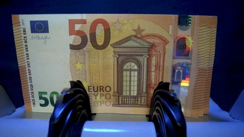 Money counting equipment for paper money calculation. Automatic mechanism for bank financial operations. Close up of euro banknotes while being counted