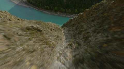 Aerial view extreme dive movement cliff peak trail texture majestic river calm surface clean water environment scenery. FPV sport drone picturesque hilly terrain nature exploration mountain park
