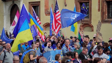 Ukrainian women and men protest against the war and Russian leader Putin. death and war in Ukraine. people with placards, flags of ukraine, italy, america. Europe, Italy Milan, April 25, 2022