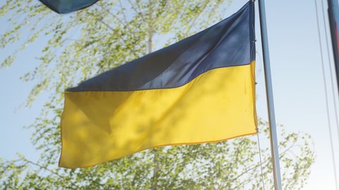 Slow motion of Ukraine flag waving background sky blue and yellow national color Ukrainian yellow-blue. Ukraine flag wind waving national symbol country. Highly detailed fabric texture flag