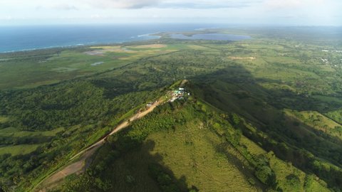 Beautiful mountain landscape on the background of the ocean. Wildlife of the Dominican Republic on a summer sunny day. Viewpoint of Mount Redonda. Green forest and meadow grass from a bird's eye view.