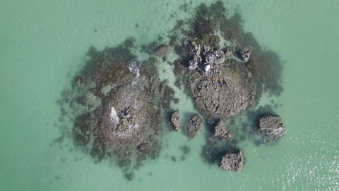 Top View Of Calm Waves Over Outcrops On Pristine Ocean. Aerial Topdown Shot