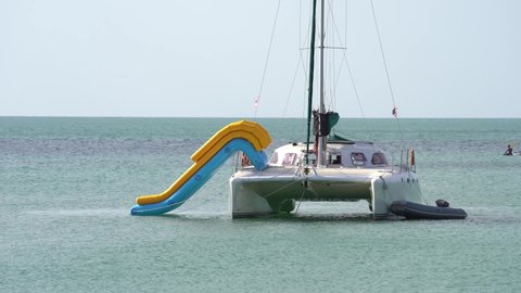 Catamaran Boat With Inflatable Slide Floating In The Gulf Of Thailand At Summer. - wide