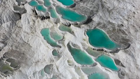 Dramatic aerial view of Travertines with turquoise water in Pamukkale, Turkey. Pamukkale (Cotton Castle) or ancient Hierapolis (Holy City), which was declared the world heritage site by UNESCO in 1988