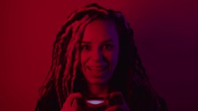Young woman with joystick in dark room. Portrait of emotional female playing console in darkness illumination of red light. - Powered by Shutterstock - Get 15% off with code: PIKWIZARD15