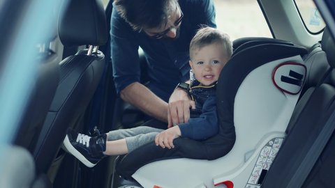 Happy Family Father And Child Boys Leisure. Father Fasten Son In Car Seat. Carefree Dad Baby Seat Sons Auto Trip Adventure. Family Parent Holidays Relationship. Car Baby Seat With Safety Seatbelt Trip