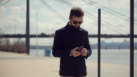 Successful Confident Businessman Talking On Phone.Attractive Young Businessman In Sunglasses Using Mobile Phone And Call.Businessman Talking By Smartphone.Handsome Attractive Man Talking By Smartphone