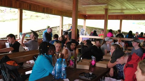Kilimanjaro. Tanzania. Africa - 12.24.2021 Entrance to Kilimanjaro National Park- Machame Gate, Tourist Shelter. Tourists are preparing for the hike, have a lunch and wait for guides with permits