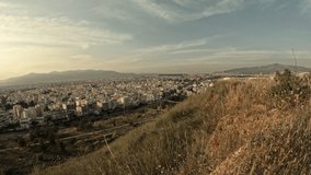 Time lapse video, shot from a hill shows a view of north suburbs of Athens city. High angle view with blue sky and clouds passing by. Unedited video.