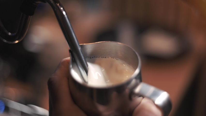 Process of preparing milk foam for cappuccino or latte, heating and whipping. Barista steaming milk in the pitcher. slow motion. | Shutterstock HD Video #1089927035