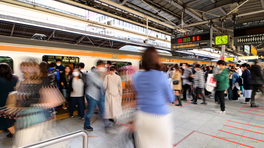 Tokyo, Japan - April, 2022: Timelapse of passengers of JR Chuo Line board and alight the Train at Tokyo Station during evening rush hour. Mass transportation and train travel concept.