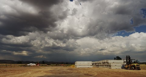 Highway infrastructure loading and maintenance area alongside an interstate highway in Arizona, with threatening monsoon storm clouds.