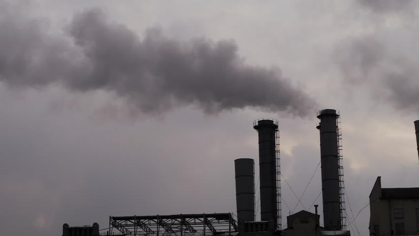 Factory smokestack, chimney silhouettes emitting smoke against grey sky - slow motion. Environmental pollution, ecology problems, industrial emissions, manufacturing concept
