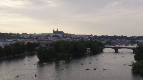 Lots of pedal boats on Vltava river with Prague castle in the distance.