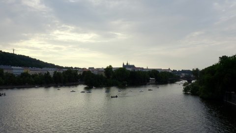 Vltava river with lots of pedal boats and Prague castle in distance.