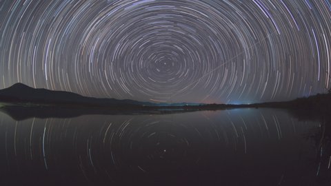 Beautiful winter scene in Timelapse video 4K with mountains in the background. The northward star trails is very beautiful in Mae Pon Reservoir, Sopphat, Lampang, Thailand.