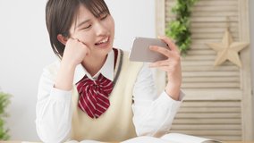High school girls skipping studies to look at their smartphones