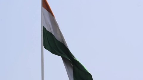 India flag flying high with pride in blue sky, India flag fluttering, Indian Flag on Independence Day and Republic Day of India, tilt up shot, waving Indian flag, Flying India flags