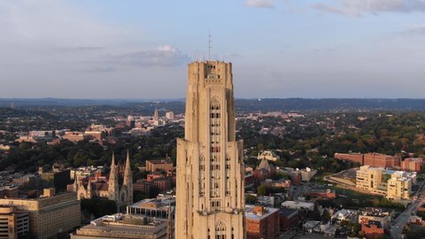 A "zolly" aerial establishing shot of the top of the Cathedral of Learning in Pittsburgh's Oakland district on an early summer evening.