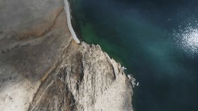 Beautiful shore of Baikal lake with clear blue water. Clouds over the lake and mountains in misty morning. Aerial drone view. Baikal lake, Siberia, Russia. Beautiful spring landscape. 
