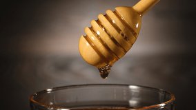 Footage organic honey dripping from wooden honey spoon background.