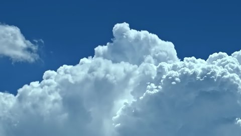 Time lapse clouds in blue sky, fast moving, sunny weather motion, Seamless Loopable, Towering Cumulus Billows, Loop features puffy white fly over a deep blue skies,