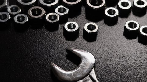 close-up nuts and wrench on dark background with light effects