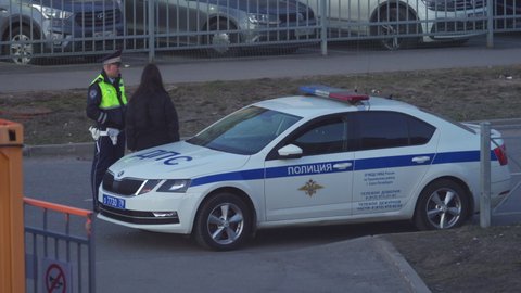 SAINT PETERSBURG, RUSSIA - CIRCA APRIL, 2022: Police officers writing traffic ticket to upset female driver, Russian police traffic cops at work.
