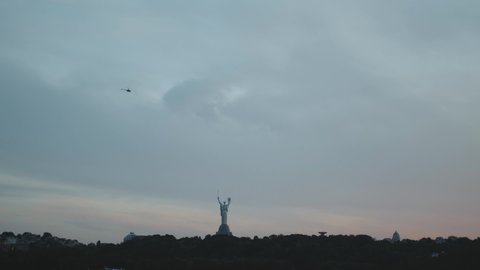 View to the Motherland statue in Kyiv while a beautiful summer sunset, slow motion. Ukraine. Monument of the Motherland in Kiev 2022. Famous monument in Ukraine Motherland. 