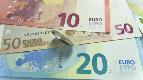 Metal Russian ruble coin spinning on Euro currency in Slow motion. Two rubles. Russian and European Union money. RF national currency. Money exchange rate. Cost of money. Euro banknotes.