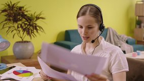 Working from home online beautiful lady architect analysing her notes and plans for work she wear the headset and smiling cute - Powered by Shutterstock - Get 15% off with code: PIKWIZARD15