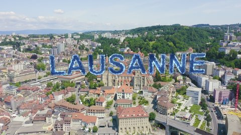 Inscription on video. Lausanne, Switzerland. Cathedral of Lausanne. La Cite is a district historical centre. Blue lights form luminous. Electric style, Aerial View, Point of interest