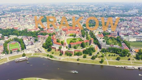 Inscription on video. Krakow, Poland. Wawel Castle. Ships on the Vistula River. View of the historic center. Appears from the sand, Aerial View, Departure of the camera