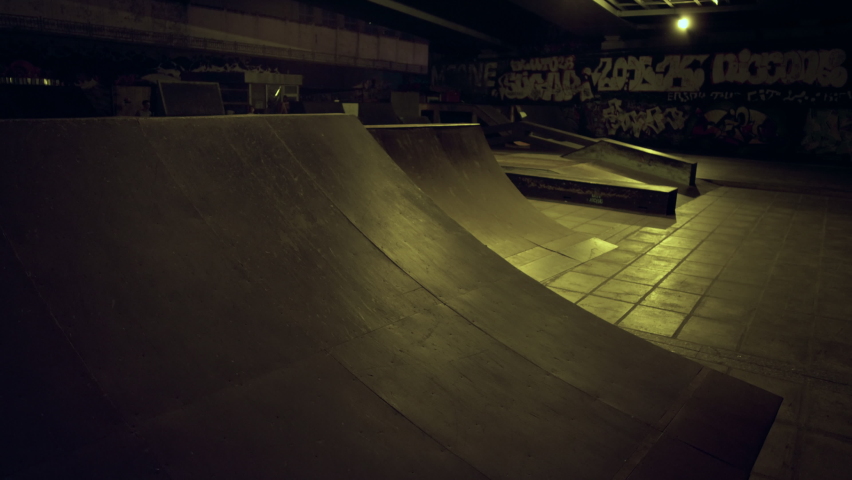 Teenage riders preparing competition together at evening skateboarding park. Young active friends riding training skills on ramp outdoors. Extreme sport youth culture action sports concept. 