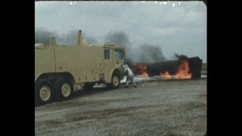 1980s: Truck sprays foam onto flames, firemen wear suits, work to fight fire, cooperate. Savannah, giraffes walk, eat tree leaves.