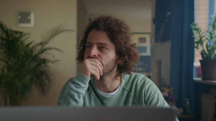 Thoughtful concerned curly men working on laptop computer looking away thinking solving problem at home office, search for inspiration make decision feel lack of ideas Royalty-Free Stock Footage #1089954185