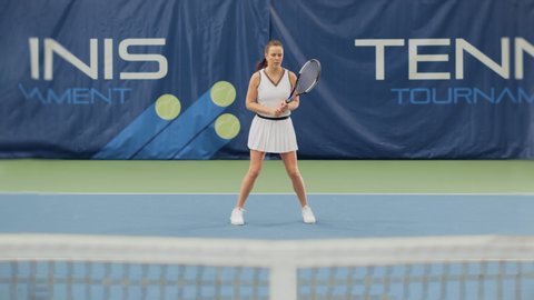 Female Tennis Player Hitting Ball with a Rocquet, 3D Special Effect Ball Flying towards the Screen with Tennis Written on it. Sports TV Woman Athlete Competing on a World Championship. VFX Animation