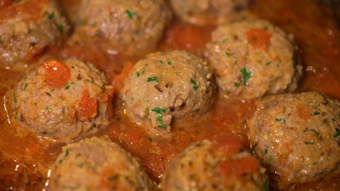 Cooking meatballs with tomato sauce in a pan 
